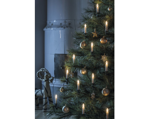 Weihnachtsbaum mit Kerzen und Ornamenten, Kamin im Hintergrund