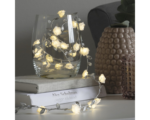 Dekorative Lichterkette mit Rosen und Blättern in einem Glas