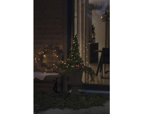 Dekorative Außenszene mit Bank, Kranz und beleuchtetem Baum