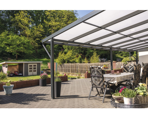 Terrasse mit Überdachung, Gartenmöbeln und Blumenkübeln in einem gepflegten Garten