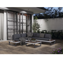 Terrasse mit Lounge-Ecke, bestehend aus Sofa, Kissen, Couchtisch und dekorativen Elementen.