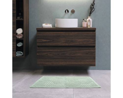 Badezimmer mit Waschbecken, Unterschrank und Badematte