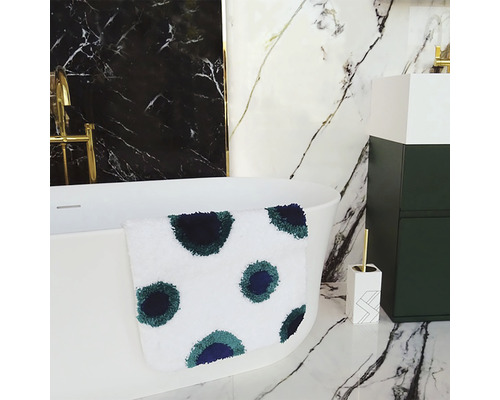 Badezimmer mit Badewanne, Waschbeckenunterschrank und Badteppich mit Punktmuster