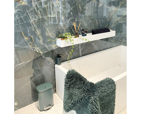 Modernes Badezimmer mit Badewanne, Ablage, Badteppich und Kosmetikartikeln