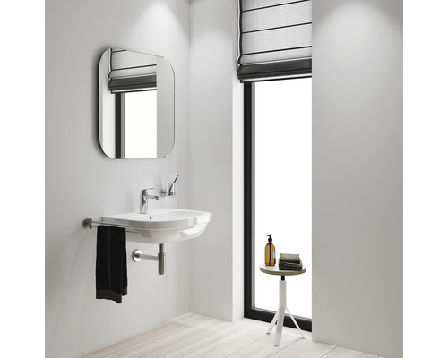 Badezimmer mit Waschtisch, Spiegel und Fenster mit Rollo