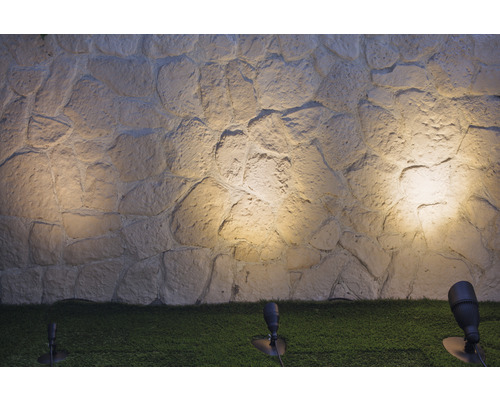 Steinwand mit Außenbeleuchtung im Garten.