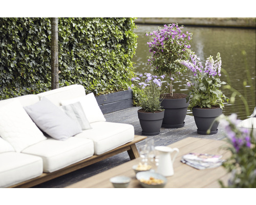 Szene mit Gartenmöbeln und bepflanzten Blumentöpfen auf einer Terrasse