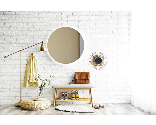 Eingangsbereich mit Spiegel, Bank, Stehleuchte und Dekorationen vor einer weißen Ziegelwand