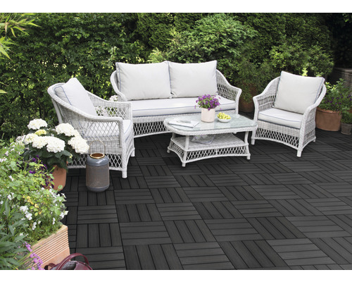 Terrasse mit dunklen Terrassenfliesen und Rattansitzgruppe im Garten
