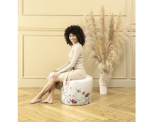 Frau sitzt auf einem runden Hocker mit Blumenmuster
