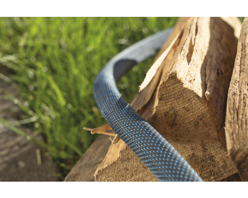Flexibler Gartenschlauch auf Holzstapel