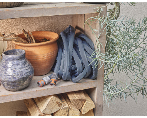 Gartenschlauch auf Holzregal mit Tontopf und Dekoration