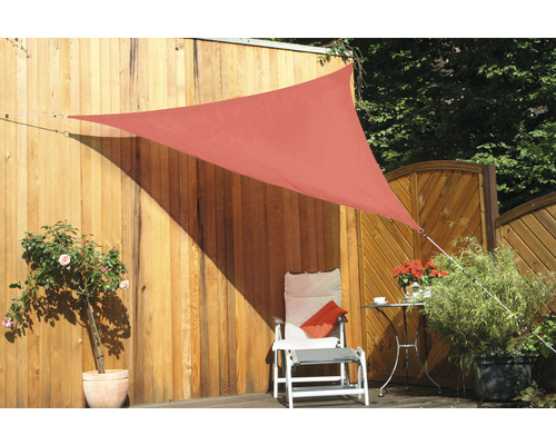 Dreieckiges Sonnensegel im Garten mit Stuhl und Pflanzen