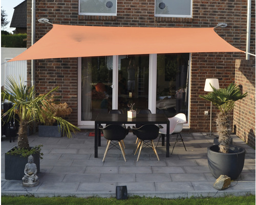 Terrasse mit Sonnensegel und Gartenmöbeln vor einem Haus
