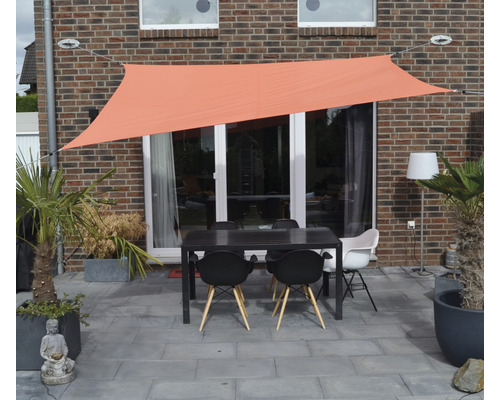 Terrasse mit Sonnensegel, Tisch und Stühlen vor einer Hauswand
