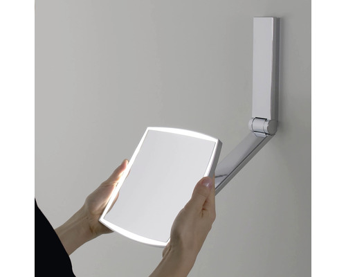 Verstellbarer Wandspiegel mit Beleuchtung wird von Hand gehalten