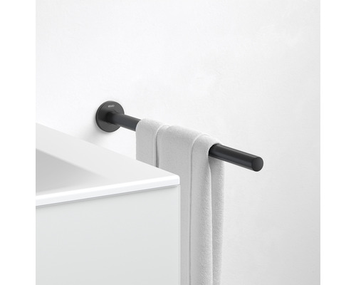 Schwarzer Handtuchhalter mit Handtuch an einer weißen Wand montiert