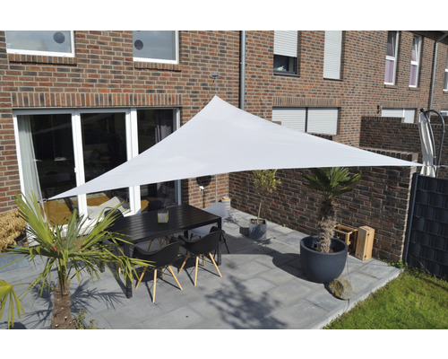 Draußenbereich mit dreieckigem Sonnensegel über Esstischgruppe