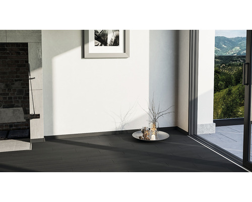 Innenraum mit dunklem Fliesenboden, Wanddekoration und Blick ins Grüne