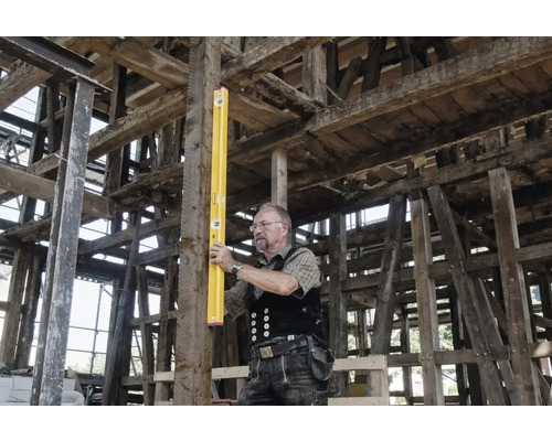 Zimmermann mit Wasserwaage im Holzbau