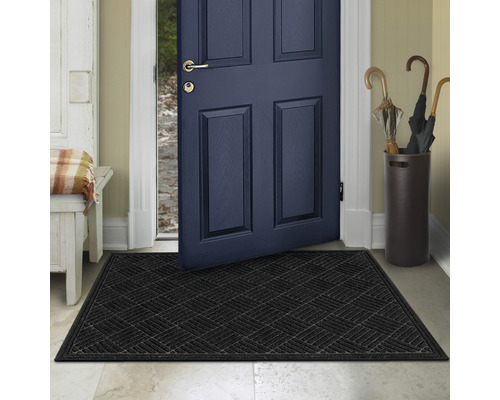 Schwarze Fußmatte vor einer offenen Haustür