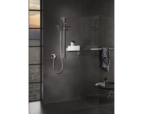 Modernes Badezimmer mit Duschbereich, Duschstange und Ablagefläche für Duschutensilien.