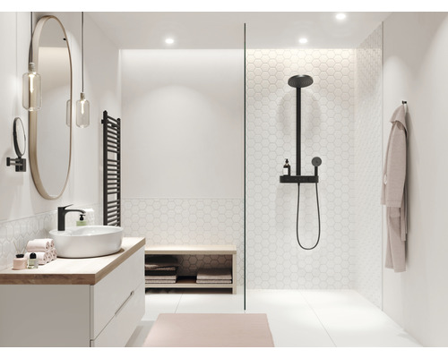 Helles Badezimmer mit Waschtisch, Spiegel, Handtuchheizkörper und Dusche.