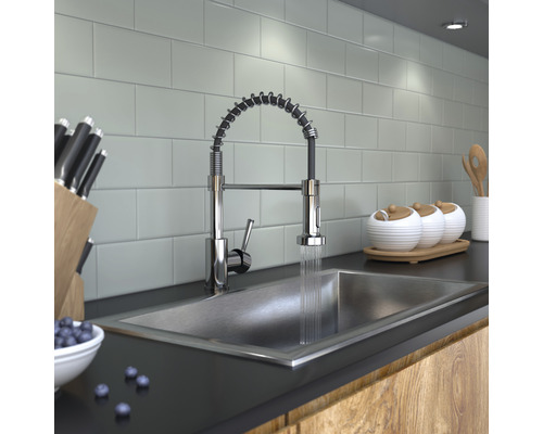 Küchenszene mit Spüle, Armatur mit Spiralfeder, Messern und Geschirr