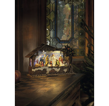 Weihnachtskrippe mit Figuren und Stall auf einem Tisch