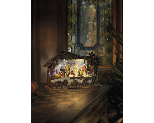 Weihnachtskrippe mit Figuren und Stall auf einem Tisch