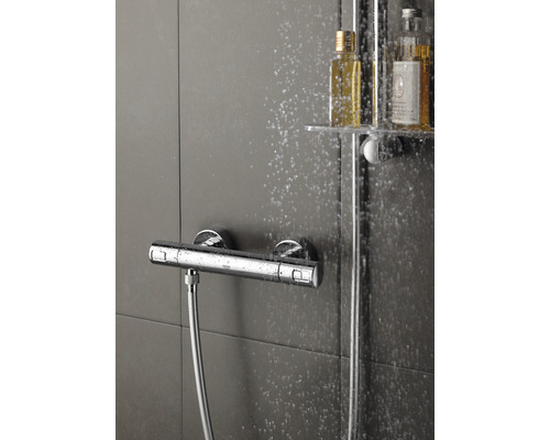 Aufputz Duscharmatur mit Brauseschlauch und Shampoo Flaschen im Duschbereich