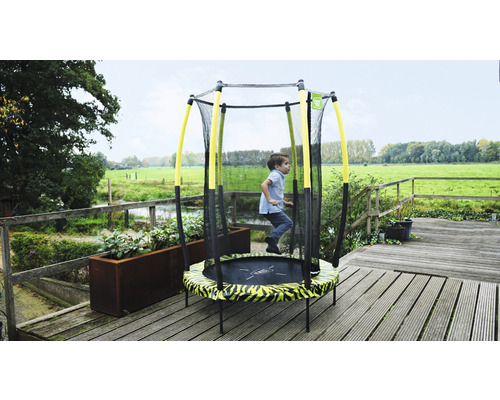 Kind springt auf einem Gartentrampolin mit Sicherheitsnetz.