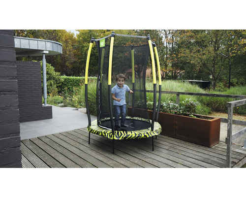 Kind springt auf einem Gartentrampolin mit Sicherheitsnetz