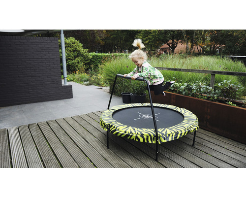 Kind springt auf einem Gartentrampolin mit Haltegriff.