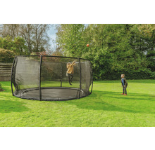 Rundes Gartentrampolin mit Sicherheitsnetz, auf dem ein Kind mit einem Ball spielt, während ein anderes Kind zusieht.