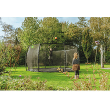 Kind springt auf Gartentrampolin mit Sicherheitsnetz
