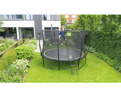 Trampolin mit Sicherheitsnetz und Leiter im Garten mit springendem Kind