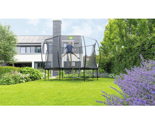 Junge springt auf einem Gartentrampolin mit Sicherheitsnetz