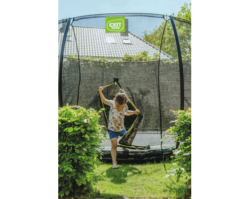 Ein Mädchen betritt ein Gartentrampolin mit Sicherheitsnetz von Exit Toys.