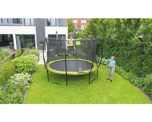 Rundes Gartentrampolin mit Sicherheitsnetz im Garten mit spielenden Kindern