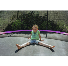 Ein Junge sitzt auf einem Gartentrampolin.