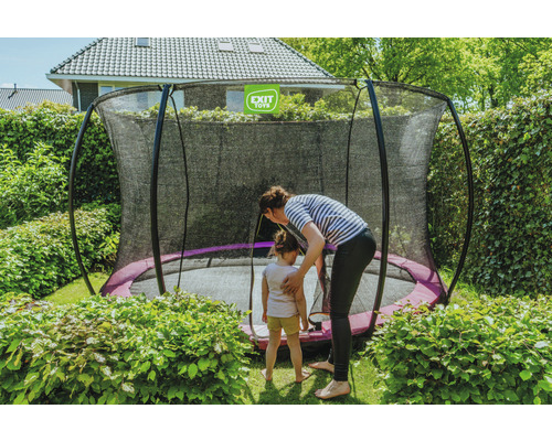Szene im Garten mit einem Trampolin mit Sicherheitsnetz, einer Frau und einem Kind.