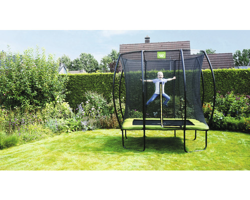 Kind springt auf einem Gartentrampolin mit Sicherheitsnetz