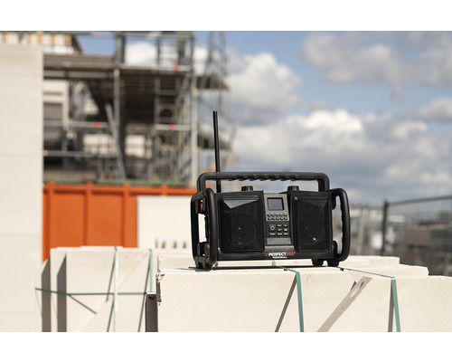 Baustellenradio auf Mauerwerk mit Baustellengerüst im Hintergrund