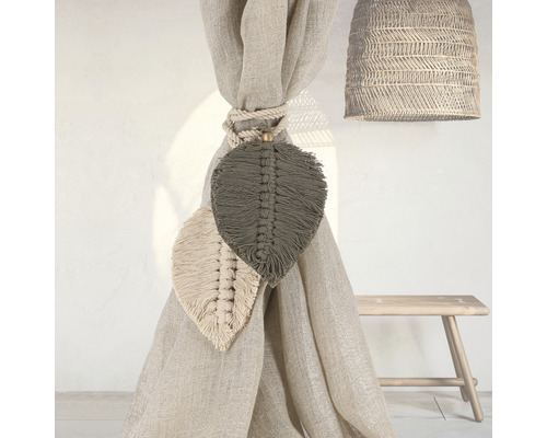 Dekorative Vorhanghalter mit Blattdesign, Seilbefestigung und geflochtener Lampe in einem hellen Raum.