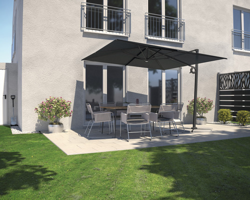 Terrasse mit Gartenschirm, Tisch und Stühlen vor einem Haus