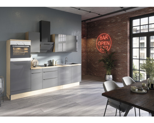 Moderne Küche mit grauen Schränken, Dunstabzugshaube und integriertem Backofen in einem hellen Raum mit Esstisch