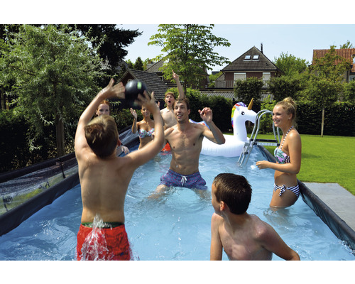 Gruppe von Personen spielt im Gartenpool mit aufblasbarem Einhorn