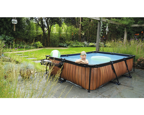 Aufbaubecken im Garten mit Kind im Wasser und Gartendekoration