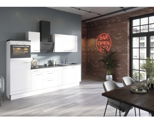 Moderne Küche mit Einbaugeräten, Spüle und Esstisch in einem loftartigen Raum mit Backsteinmauer